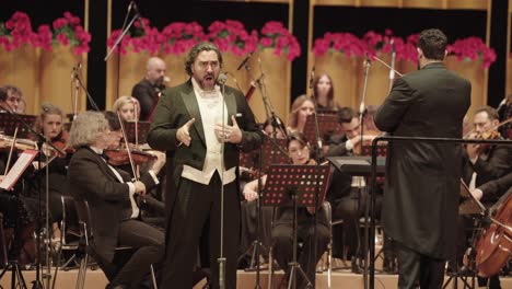 Männlicher-Opernsänger-Auf-Der-Bühne-Mit-Orchester-Und-Symphonischer-Band,-Ensemble-Führt-Italienische-Oper-In-Der-Sun-Yet-Sen-Memorial-Hall-Auf