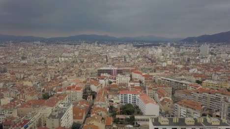 Aerial-Drone-View-above-Red-Roof-Buildings-In-Downtown-Marseille,-France-On-from-right-to-left-dolly,-cloudy-day