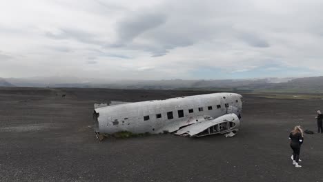 Aerial-View,-Remains-of-US-Navy-Military-Airplane-on-Black-Sand-Beach,-Iceland