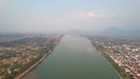 Beautiful-landscape-of-the-Mekong-River-on-a-misty-morning-in-the-Chiang-Khan-District-in-Thailand,-aerial-view-from-a-drone-flying-backward