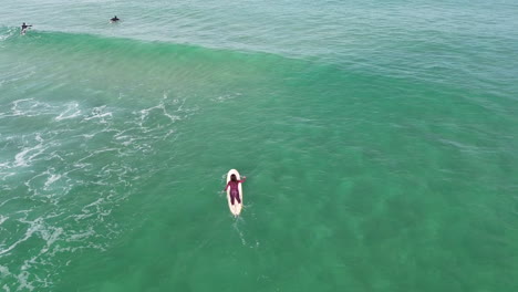 Drohnenvideo-Einer-Surferin,-Die-Allein-Auf-Einem-Longboard-Am-Bondi-Beach-In-Sydney-Aufs-Meer-Hinauspaddelt