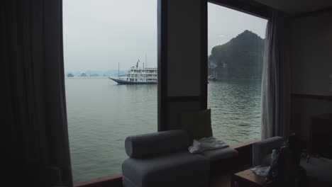 Gimbal-shot-through-the-master-suite-on-a-tourist-boat-in-Ha-Long-Bay,-Vietnam,-showing-the-bay-and-mountains-outside