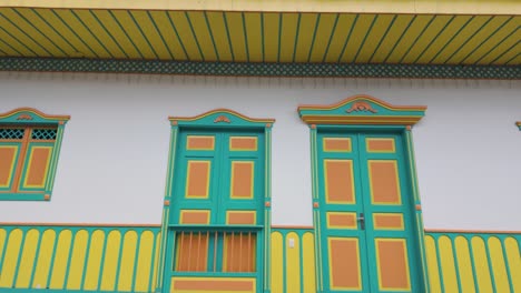 POV-Aufnahme-Vor-Dekorierten-Häusern-Mit-Farbenfrohen-Fenstern-Und-Türen-In-Kolumbien