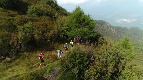 Toma-Aérea-De-Un-Grupo-De-Excursionistas-De-Montaña-Profesionales-Corriendo-Por-Un-Sendero-De-Montaña