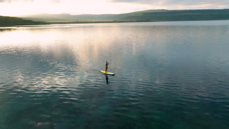 Woman-Rowing-A-Paddleboard-On-A-Lake-In-Moso-Island,-Vanuatu---Aerial-Drone-Shot