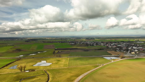 Aerial-View-Of-Serene-Rural-Farmland-With-White-Clouds-Overhead