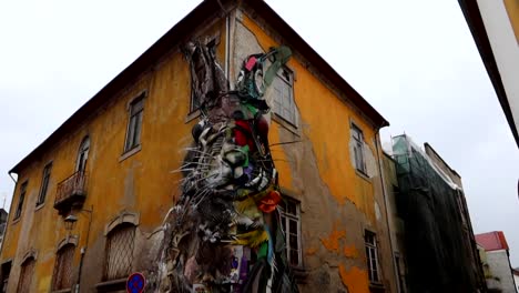 Tilt-down-shot-of-Half-Rabbit-art-on-the-intersection-of-a-yellow-old-building-in-Vila-Nova-de-Gaia