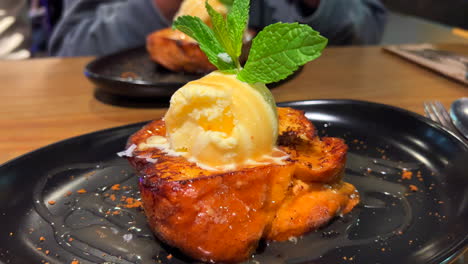 Dos-Deliciosas-Tostadas-Francesas-Con-Helado-De-Vainilla-Y-Hojas-De-Menta-Fresca-En-Un-Plato,-Postre-Dulce-En-Un-Restaurante,-Fotografía-Con-Flash-De-Fondo,-Toma-De-4k