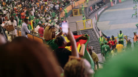 Zwei-Frauen-Tanzen-Und-Schwenken-Die-Flagge-Kameruns-Auf-Der-Tribüne