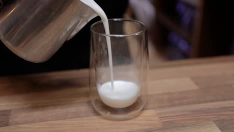 Barista-Gießt-Aufgeschäumte-Milch-In-Ein-Glas-Und-Bereitet-Einen-Latte-Kaffee-Zu