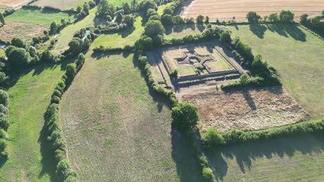 Forward-Arc-Aerial-of-Large-Historical-Ruins-Building-Surrounded-by-Fields