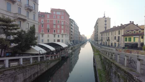 View-down-Via-Vigevano-canal-on-a-very-quiet-morning-with-very-few-people-awake-in-Milan,-Italy