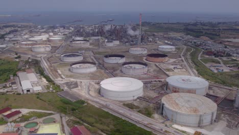 Aerial-establishing-shot-of-an-old-empty-fuel-gas-storage-facility-and-oil-refinery-in-Catania,-Sicily,-Italy