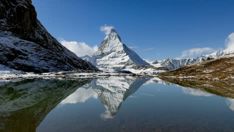 Stunning-clear-Lake-Riffelsee-reflection-Matterhorn-Zermatt-Switzerland-Glacier-Gornergrat-Railway-train-stop-autumn-October-clear-afternoon-blue-sky-first-snow-landscape-scenery-Swiss-Alps-zoom