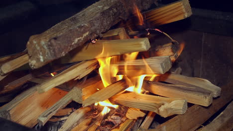 Brennholz-Gestapelt-In-Heißen-Lagerfeuer-Beginnen-Zu-Brennen-Auf-Dunklen-Schwarzen-Nacht