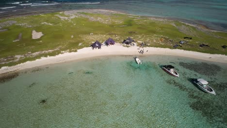 A-kite-camp-on-cayo-vapor-with-people-and-gear,-activity-on-a-sunny-day,-aerial-view