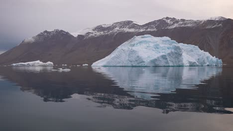 Iceberg-in-Arctic-Circle,-Ice-Flowing-in-Calm-Sea-Water-by-Coastline-of-Svalbard,-Norway