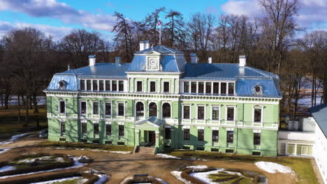 Kokmuiza-manor-in-Valmiera-parish-on-sunny-spring-day-in-aerial-parallax