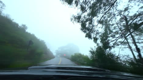 POV-car-front-view-driving-at-mountain-road-foggy-skyline-dark-deep-edge-altitude-experience-point-of-view-from-driver's-seat,-street