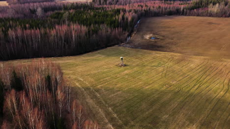 Acercamiento-Aéreo-De-La-Torre-De-Caza-En-El-Campo-Al-Lado-Del-Bosque.