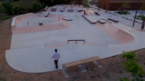Skaters-displaying-mesmerizing-skills-and-balance-in-evening-skatepark,-aerial-reveal