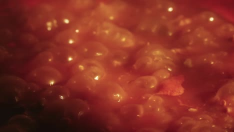 Close-up-view-of-a-simmering,-bubbly-tomato-sauce-