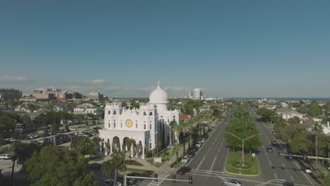 An-aerial-view-of-the-Sacred-Heart-Church-and-Bishop's-Palace-under-the-late-afternoon-blue-skies-on-Broadway-in-Galveston,-Texas