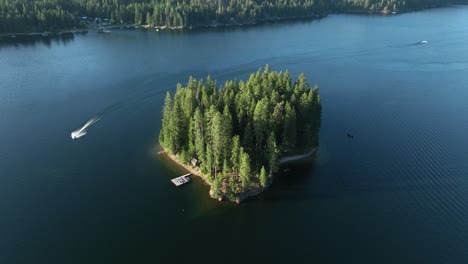 Drone-shot-of-a-boat-circling-an-island-in-a-lake