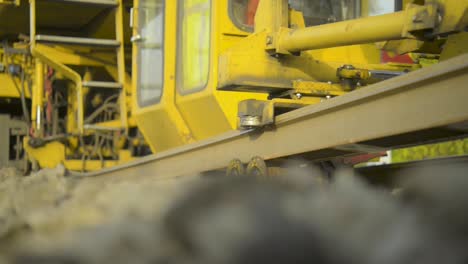 Close-up-of-a-yellow-construction-train-on-tracks-during-daytime