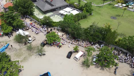 Vista-Aérea,-Procesión-En-La-Playa-De-Samuh-Durante-La-Ceremonia-Melasti-Antes-Del-Día-Silencioso-De-Nyepi