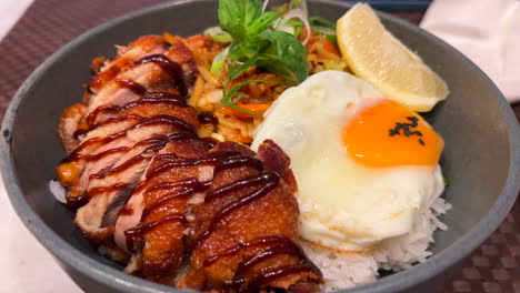 Tasty-Thai-crispy-fried-duck-with-fried-egg,-vegetables-and-white-rice,-spicy-Asian-food,-4K-shot