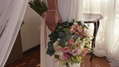 Mano-De-Mujer-Vestida-De-Blanco-Sosteniendo-Un-Hermoso-Ramo-De-Flores