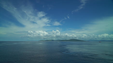 Garden-Island-Taveuni-Island-wide-open-Pacific-Ocean-Boat-cruise-Fiji-port-marina-shoreline-beach-front-jungle-rainforest-Viti-Levu-Group-landscape-nature-deep-blue-sky-clear-cloudy-pan-to-the-right