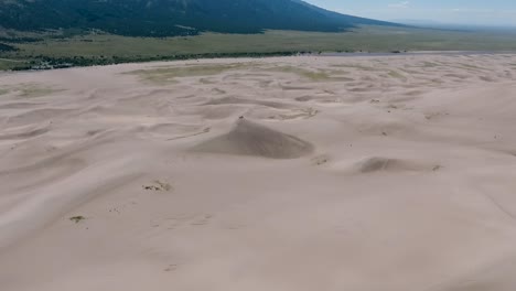Eine-Spektakuläre-Hochfliegende-Landschaftsaufnahme-Mit-Einer-Drohne-über-Den-Großen-Sanddünen-Von-Colorado,-Wo-Sich-Die-Höchsten-Sanddünen-In-Ganz-Nordamerika-Befinden,-Mit-Den-Sangre-De-Cristo-Bergen-Im-Hintergrund