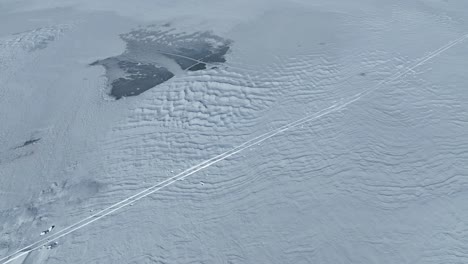 Drohnenflug-über-Einen-Zugefrorenen-See,-Bei-Dem-Die-Bäume-Des-Waldes-Sichtbar-Werden