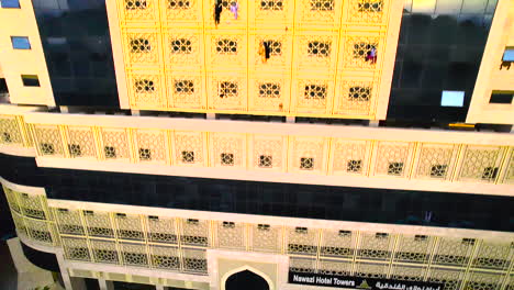 Eine-Drohne-Steigt-An-Den-Goldgemusterten-Fenstern-Und-Schwarzen-Markisen-Eines-Hotels-In-Saudi-Arabien-Entlang