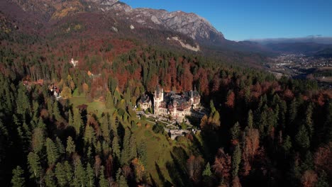 Schloss-Peles-Mit-Herbstlichem-Wald-Im-Hintergrund,-Im-Warmen-Licht-Der-Sonne,-Luftaufnahme