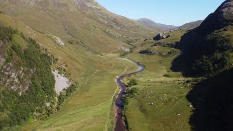 Aerial-drone-fly-above-green-Scotland-Ben-Nevis-River-Valley-natural-environment-landscape-in-european-summer,-skyline-with-pale-green-mountainous-land