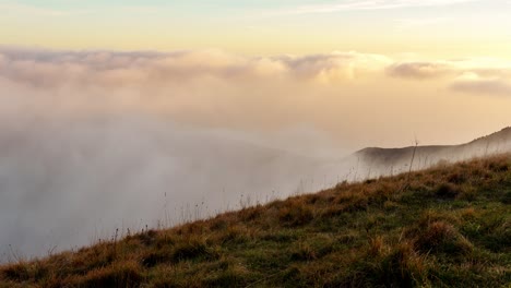 Time-Lapse-in-Liguria-Genoa-Italy-clouds-fly-above-mountain-tops-hiking-fields-in-European-winter,-skyline-background-with-sunrise-golden-gradient