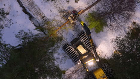 Harvester-Fällen,-Entasten-Und-Absägen-Von-Bäumen-Im-Verschneiten-Wald