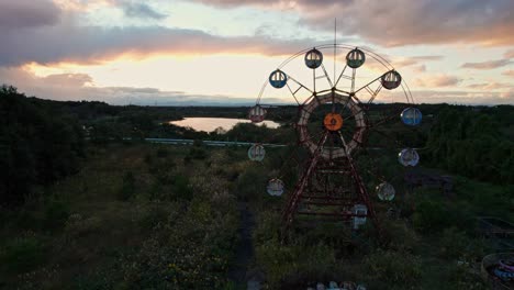 Aerial-Drone-Closeup-Ferris-Wheel-Abandoned-Amusement-Park-in-Japan-Sunset-Sky-Kejonuma-Leisure-Island,-rural-overgrown-natural-landscape-in-Asia,-rare-travel-spot
