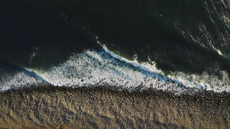 Static-aerial-above-ocean-waves-rhythmically-breaking-on-rocky-Oregon-shore