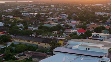 Sunset-glow-spreads-across-tropical-neighborhood-to-families-lined-up-on-street-to-watch-parade