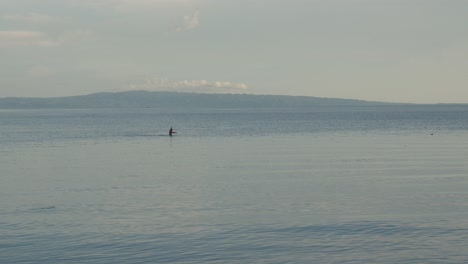 Persona-De-Una-Aldea-En-Filipinas-Pescando-En-El-Océano-Con-Montañas-Al-Fondo-Durante-El-Amanecer.