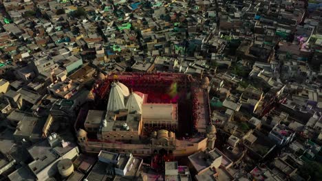 AERIAL-DRONE-VIEW-Drone-camera-is-coming-towards-the-left-side-and-many-people-are-painting-the-temple-with-colors-by-flying-colors-with-their-different-theme-in-the-temple