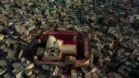 Vista-Aérea-De-Drones,-La-Cámara-De-Drones-Viene-Hacia-El-Lado-Izquierdo-Y-Muchas-Personas-Están-Pintando-El-Templo-Con-Colores-Volando-Con-Gran-éxito-Con-Su-Tema-Diferente-En-El-Templo