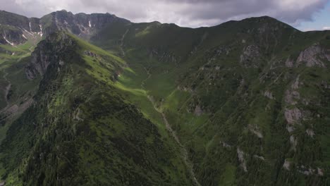 Üppiges-Tiganesti-Tal-Im-Bucegi-Gebirge-Unter-Einem-Dynamischen-Himmel,-Luftaufnahme