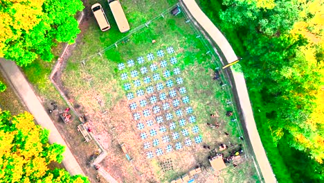 Drones-being-prepared-for-nighttime-display-launch-at-Wine-Fair-in-Bordeaux-France,-Aerial-top-view-descent-shot