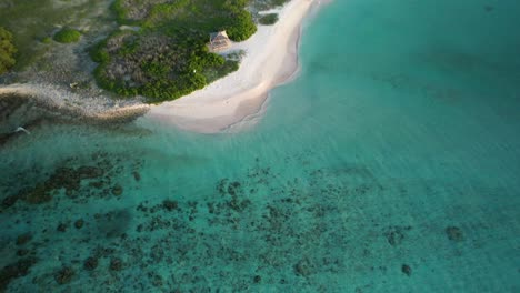 Isla-Noronky-En-El-Archipiélago-De-Los-Roques-Al-Atardecer,-Aguas-Turquesas-Bañando-Suavemente-Las-Costas-De-Arena-Blanca,-Serena-Escena-Tropical,-Vista-Aérea