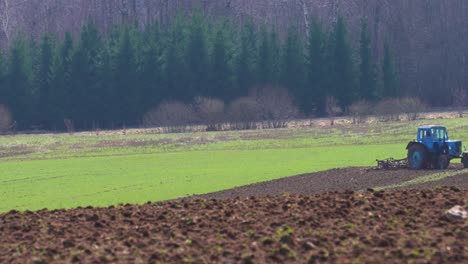 Gas-De-Escape-Del-Viejo-Tractor-Soviético-Mientras-El-Agricultor-Cultiva-El-Campo-De-Cultivo.